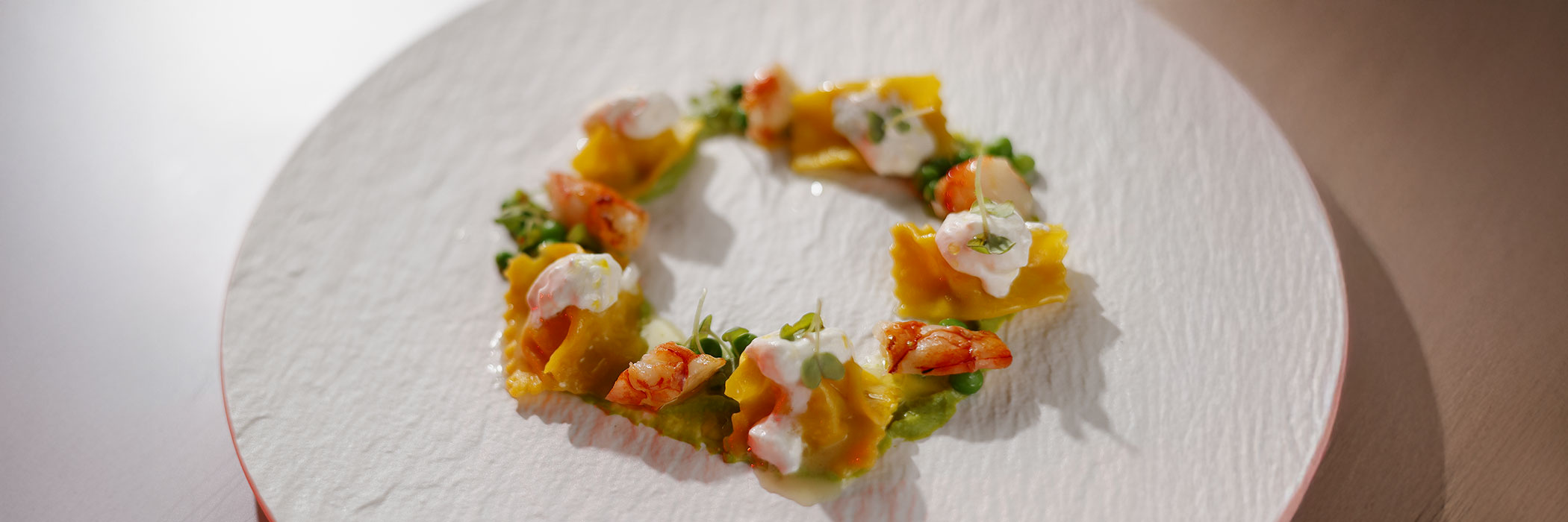 MAIA - ricetta per la realizzazione di ravioli farciti con gamberi ed erba cipollina, saltati con burro al limone, stracciatella e crema di piselli